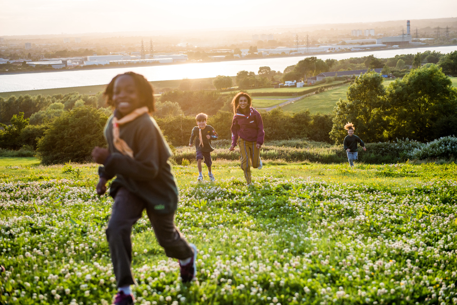Cubs running through the fields of Gilwell Park with the city of London in the background