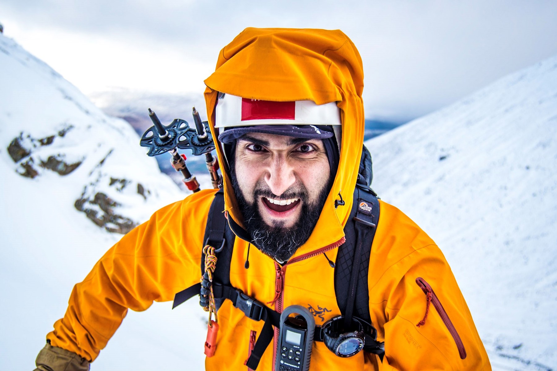 Mahroof smiling nearing a snow peaked summit