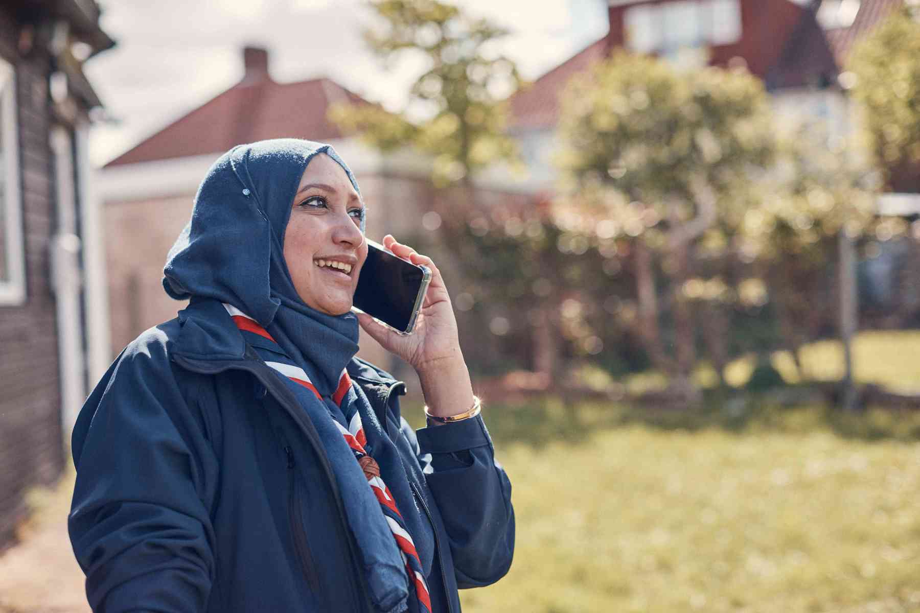 A Squirrels leader, wearing a red, white and blue scarf, smiles while talking on a mobile phone