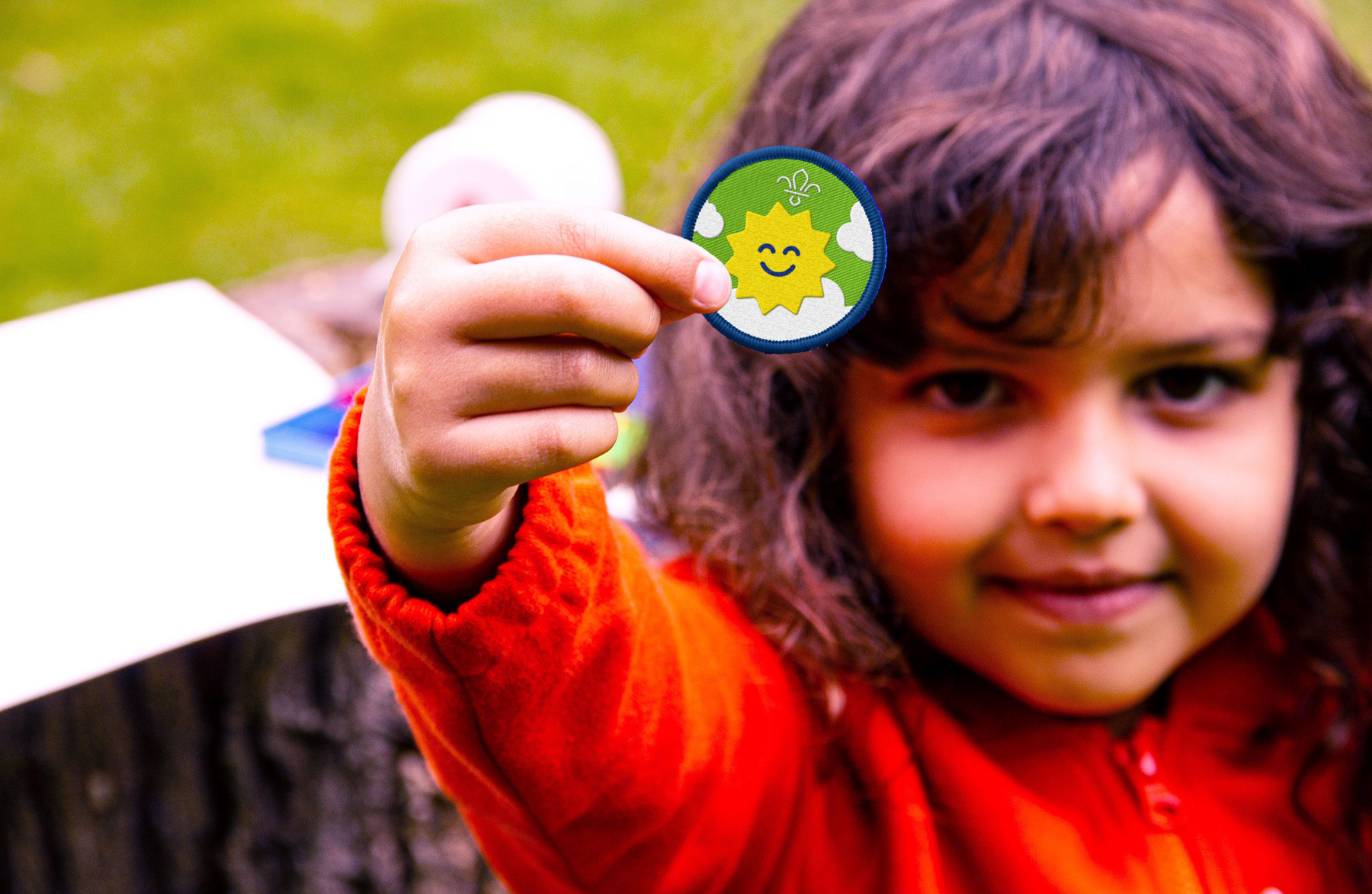 A Squirrel Scout holds up the Feel Good Activity Badge.