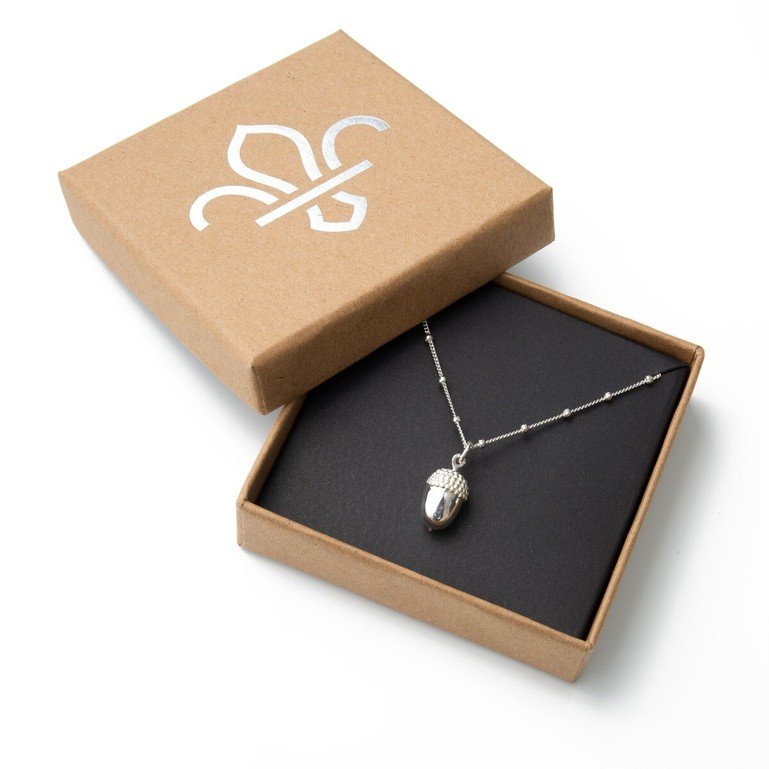 Sterling Silver acorn necklace in brown-paper coloured box with white fleur de lis logo on