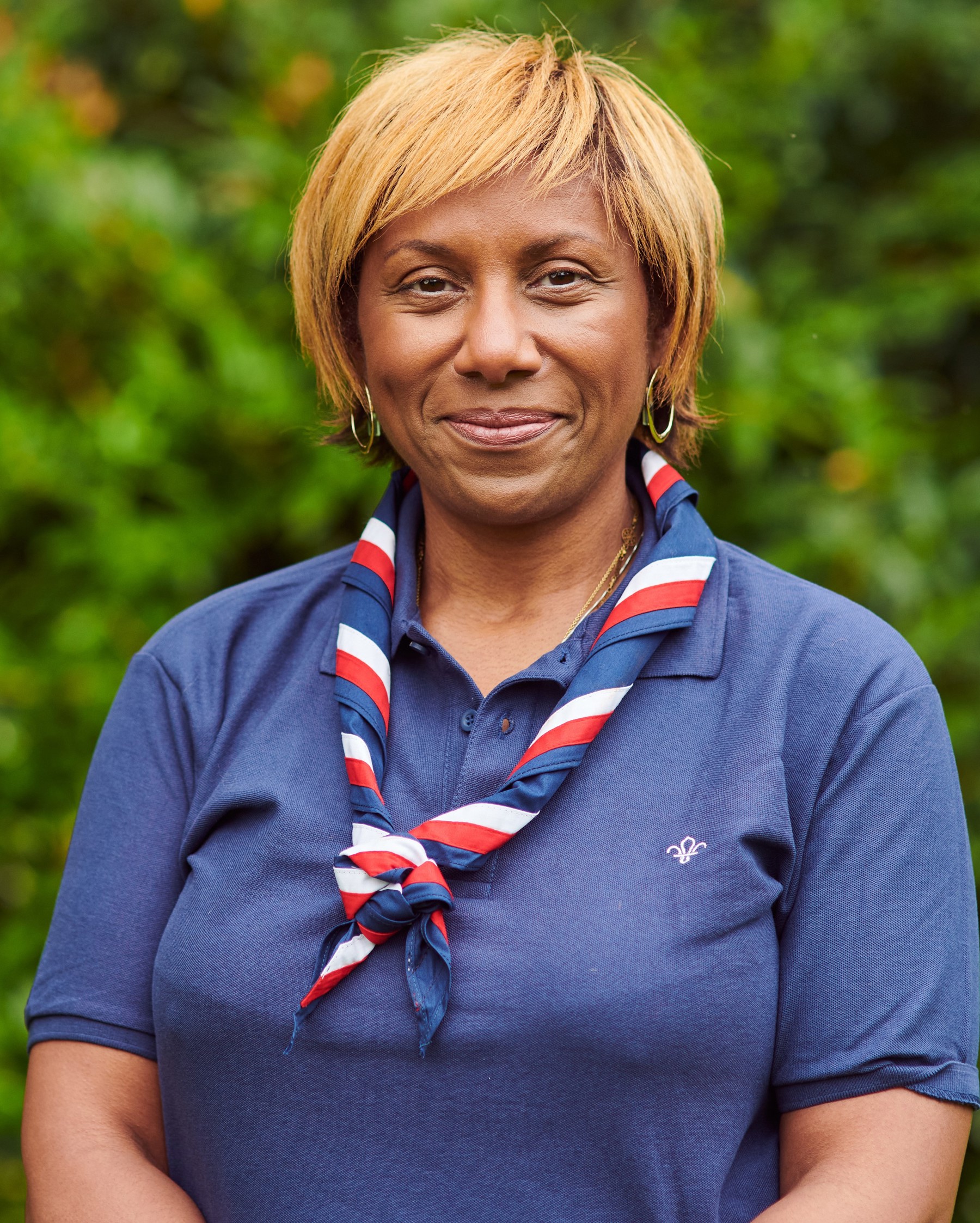 Our Board of Trustee member Sharon smiles at the camera wearing a navy polo shirt with the Scout logo and a necker