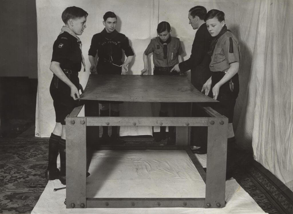 Black and white photo of a group of five Scouts working together to build an air raid shelter