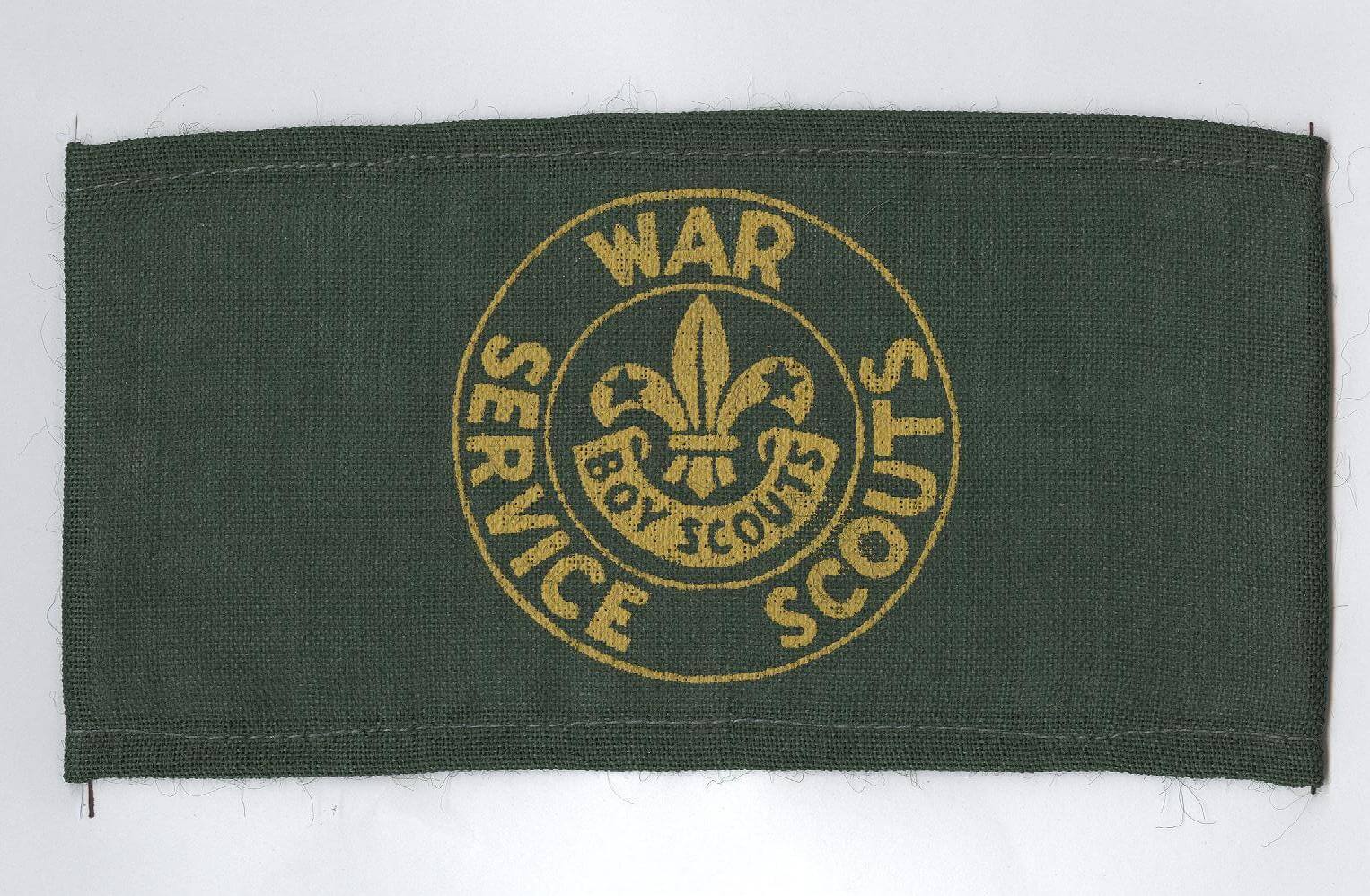 Green armband with a yellow circular emblem, featuring the Scouts logo and the words 'War Service Scouts'