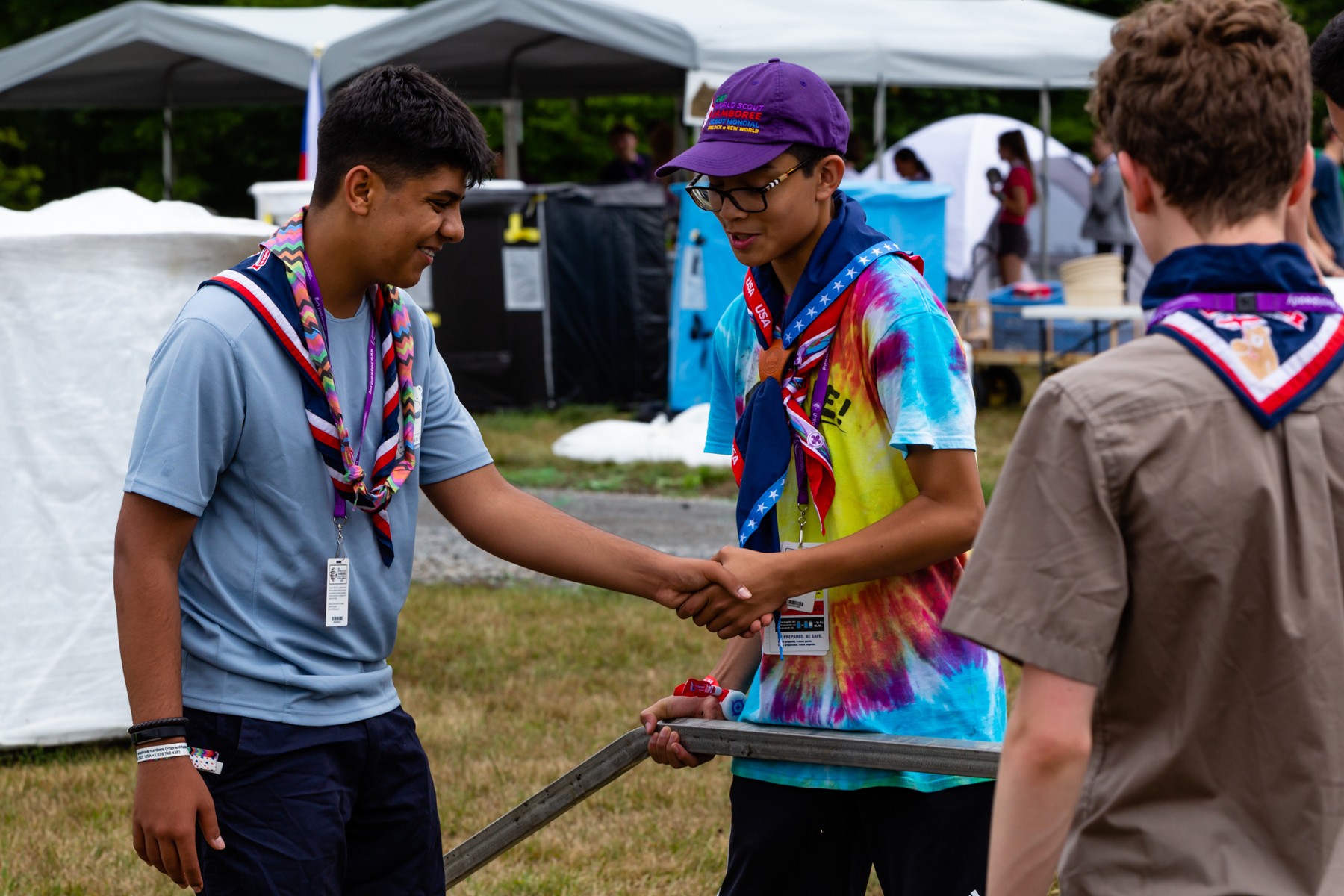 Explorer in a UK necker shakes hands with a US Scout at the 2019 World Scout Jamboree