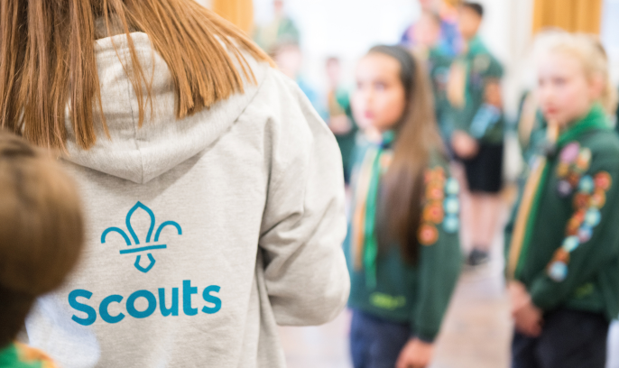 Female volunteer with her back turned showing the Scouts logo