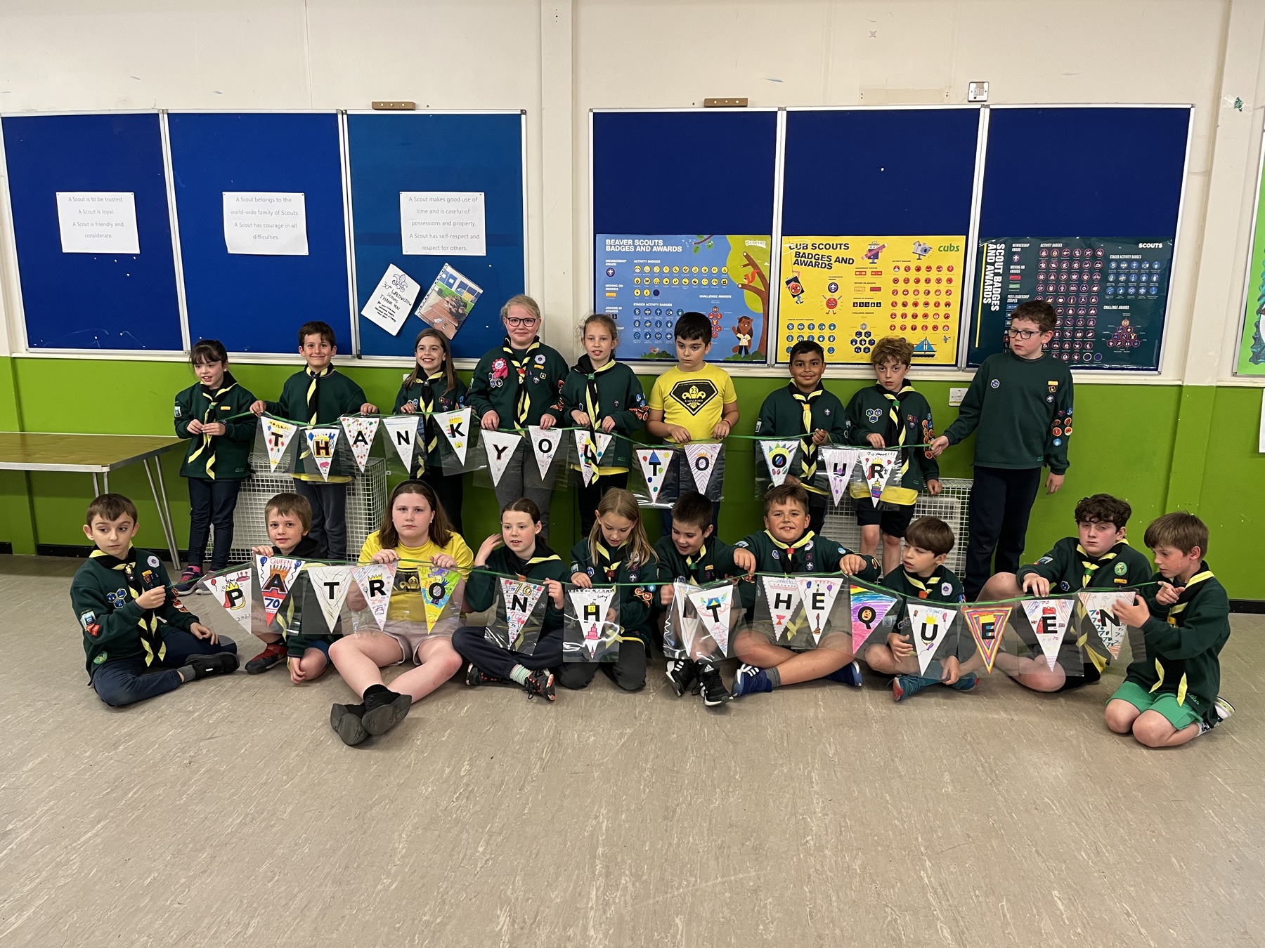 Cub Scouts gathered together holding bunting they've made for the Jubilee and Thank You Day