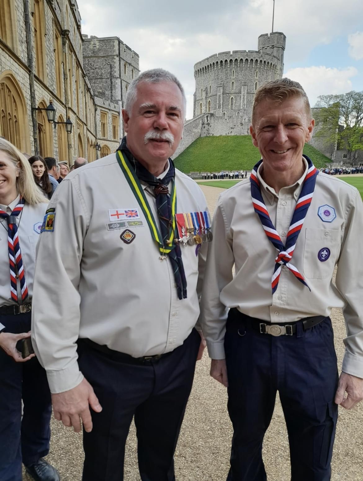 Steve is stood on the left next to Tim Peake, with Windsor castle behind them. They are both wearing Scouts uniform and their neckers. Steve's Queen Scout award, along with various other medals and badges, can be seen.