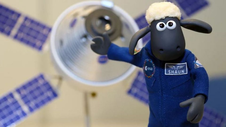 Shaun the Sheep in space uniform with equipment behind 