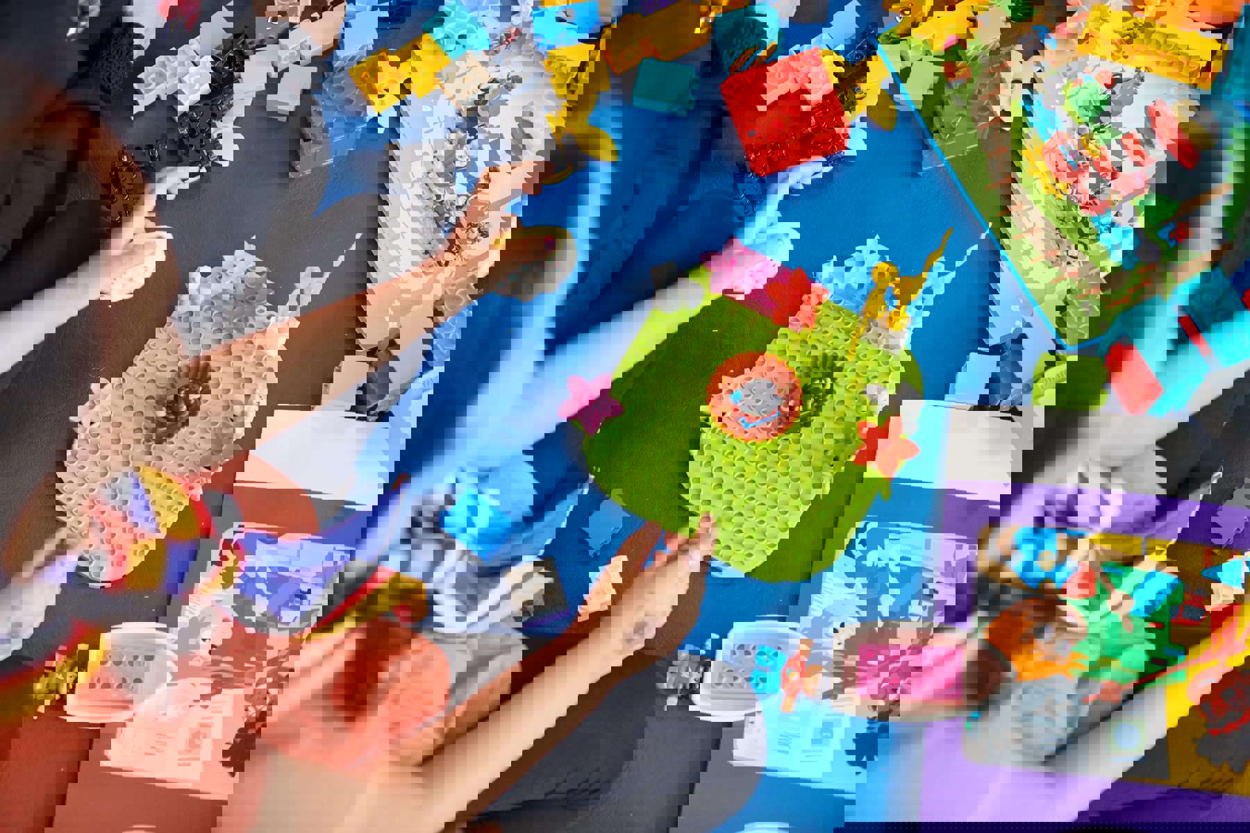 Overhead shot of a Squirrel playing with Lego that's scattered over a blue floor.