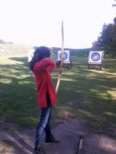 Rehneesa aims a bow and arrow while taking part in archery.