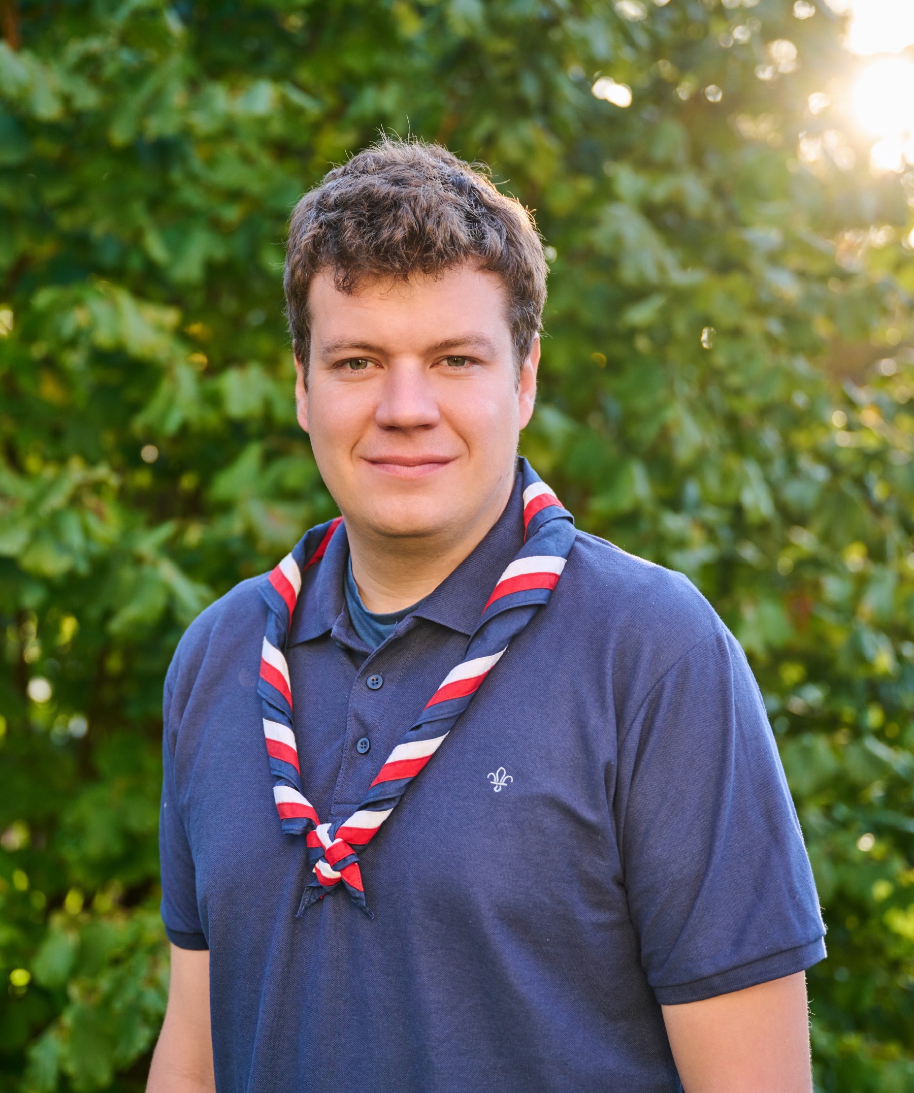 Jack Caine, UK Commissioner for People, in a blue, white and red necker at Gilwell Park