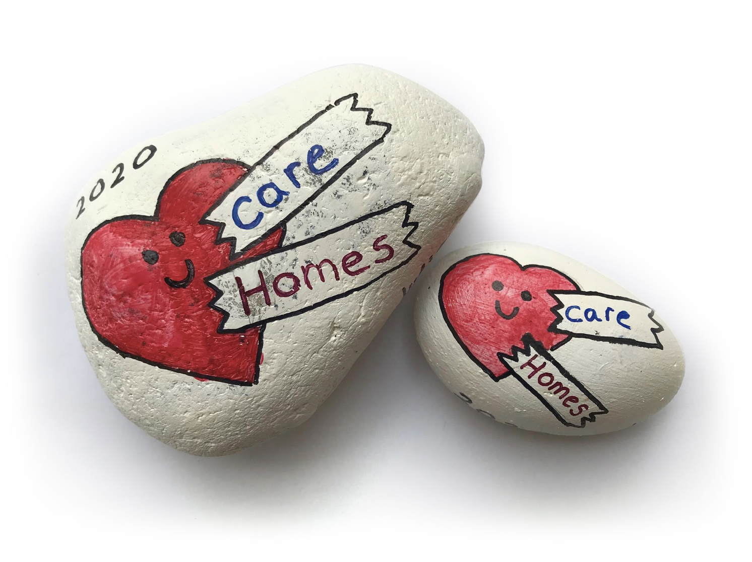 Two stones are side by side and painted with a red heart that has a black smiley face. The year 2020 is painted on in black above the heart on the left stone, and both of them have 'care homes' painted on in ribbons slightly overlapping the hearts.