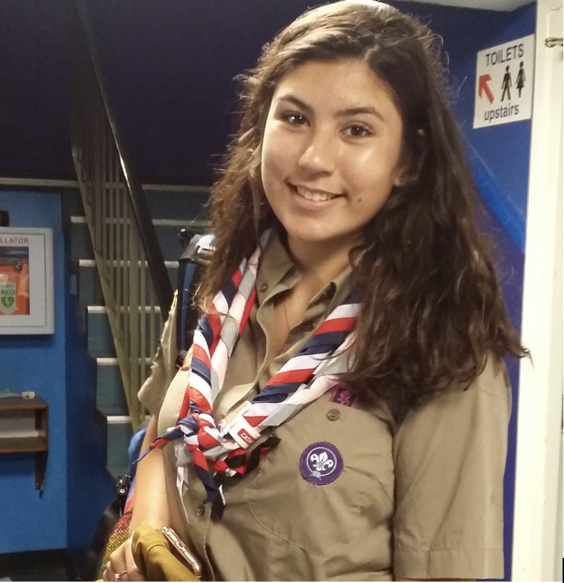 Mike's daughter is wearing her Scout uniform and necker and smiling at the camera. She's wearing her shoulder-length, brown hair down as she gets ready to go to the 2019 World Scout Jamboree.