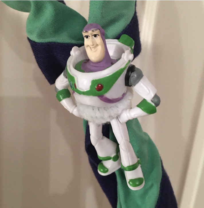 Mike's Buzz Lightyear figure is hanging from his woggle on his green and navy necker.