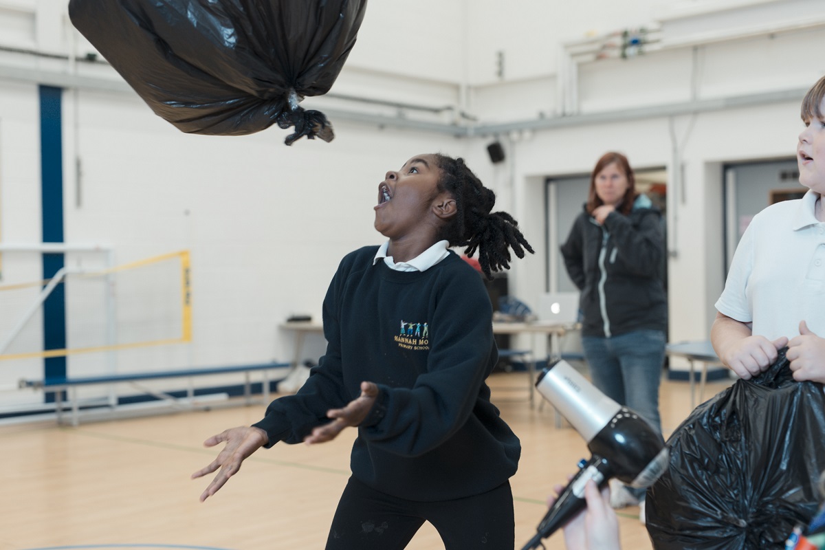 A 1st Dings cub scout tries to keep an inflated bin bag in the air