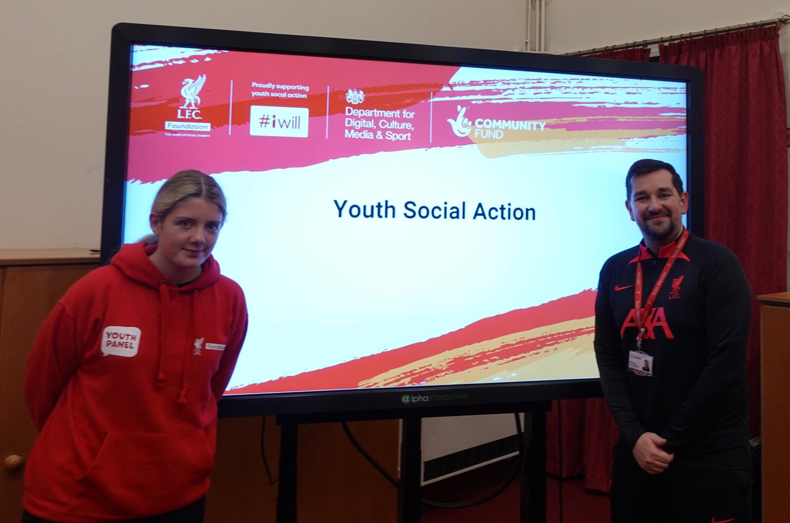 Rosie and her coach stood in front of a screen that says Youth Social Action