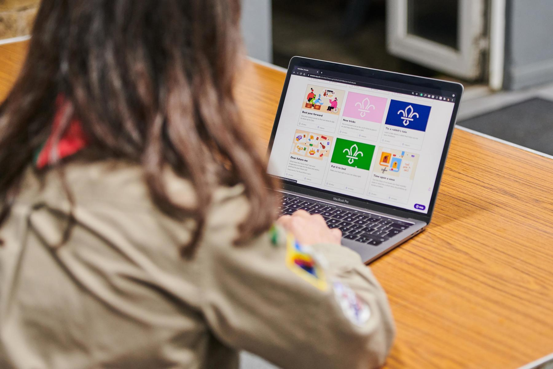 An Explorer wearing uniform looks at the activity finder on the Scouts website.