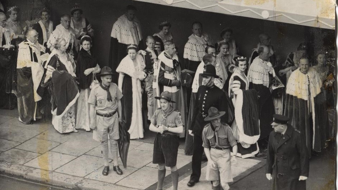 Black and white photo of Peers entering Westminster Abbey with Scouts helping marshall for the 1953 Coronation