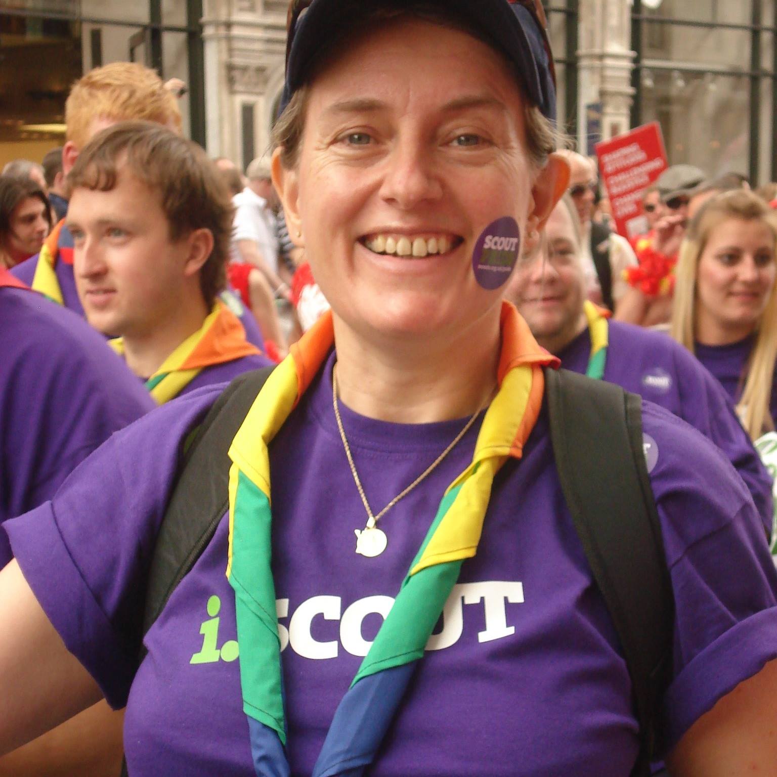 Smiling, Lisa wears a rainbow necker. She wears a 'Scout Pride' sticker on her face.