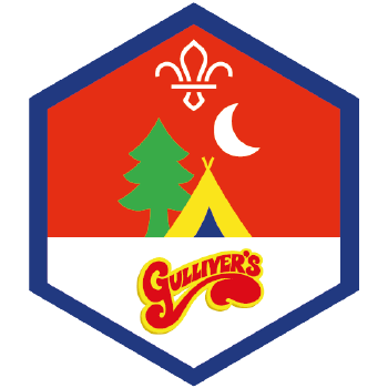 A red hexagonal badge showing a tent, tree and a cresent moon with the word Guillivers written below.