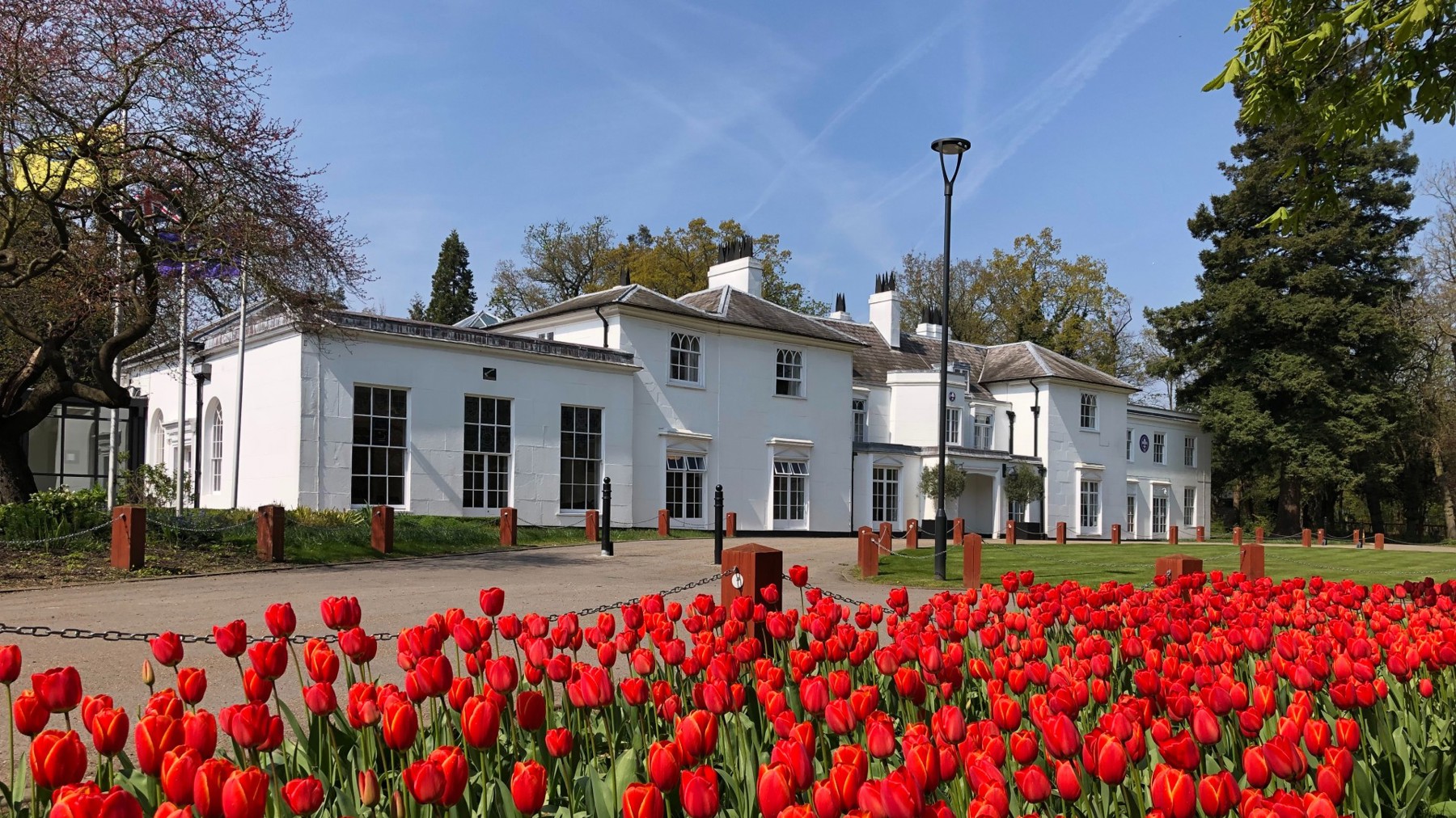 The exterior of the White House at Gilwell Park with red tulips in front
