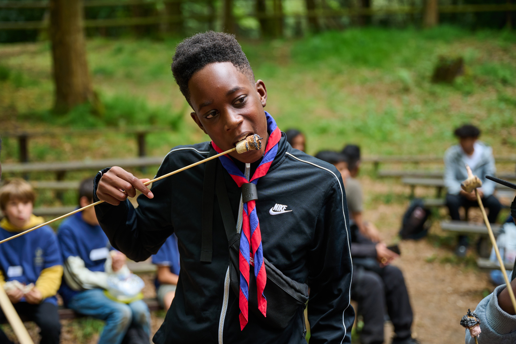 A Scout eating a marshmallow