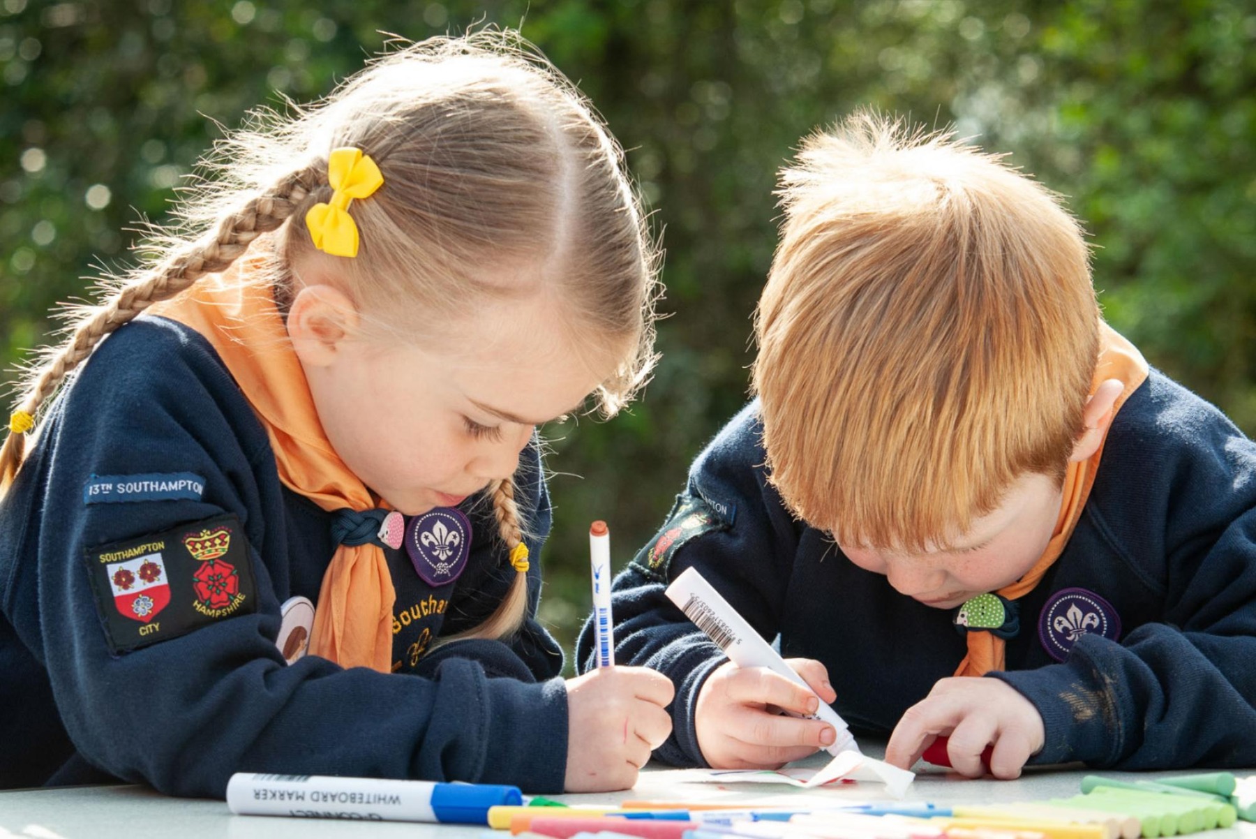 Two children using colouring pens