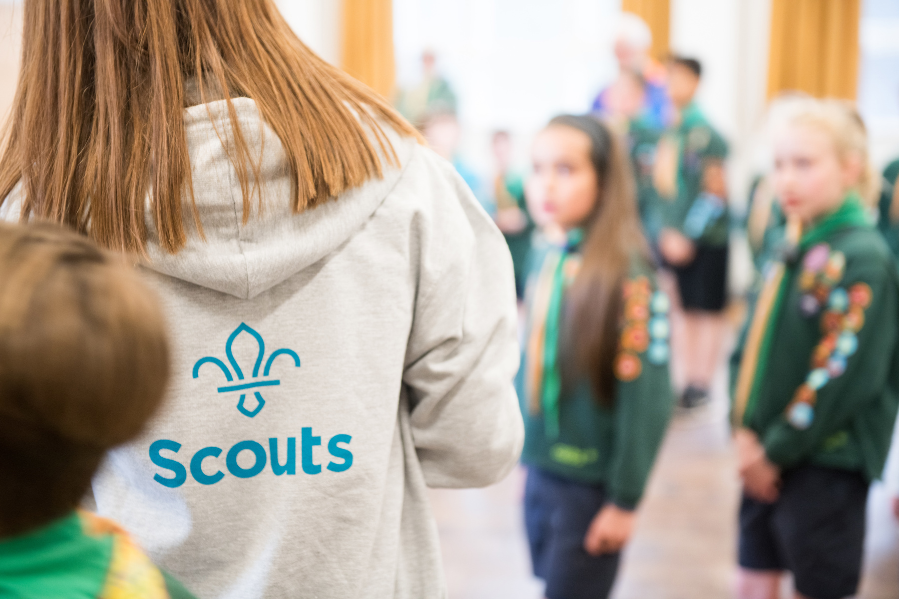 Female volunteer with her back turned showing the Scouts logo