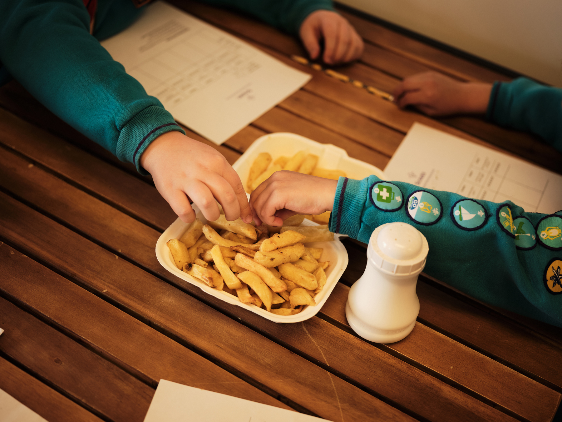 A group of Beavers tuck into a plate of chips in a sit-down restaurant.