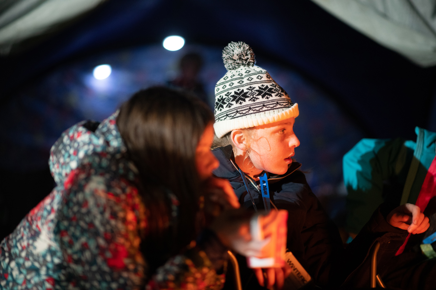 A Scout in a knitted hat sits outside.