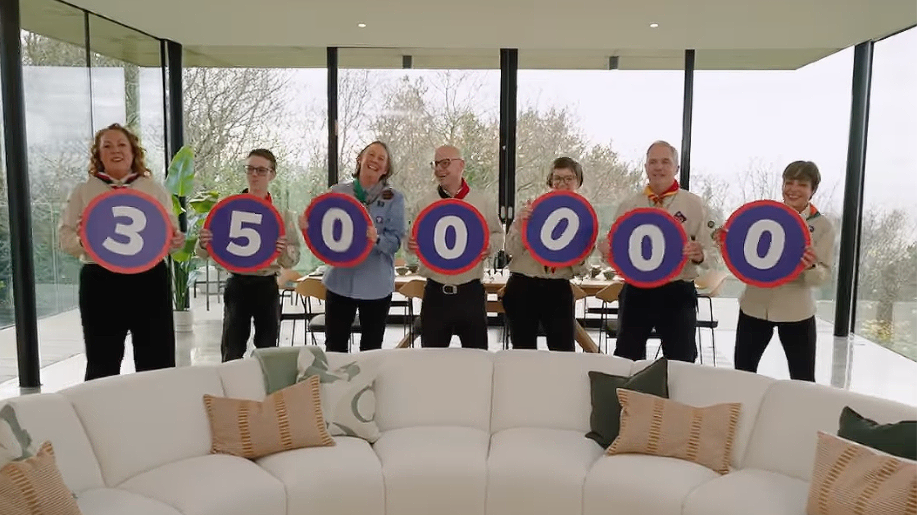 A row of Scouts volunteers hold up numbers which read 3.5 million