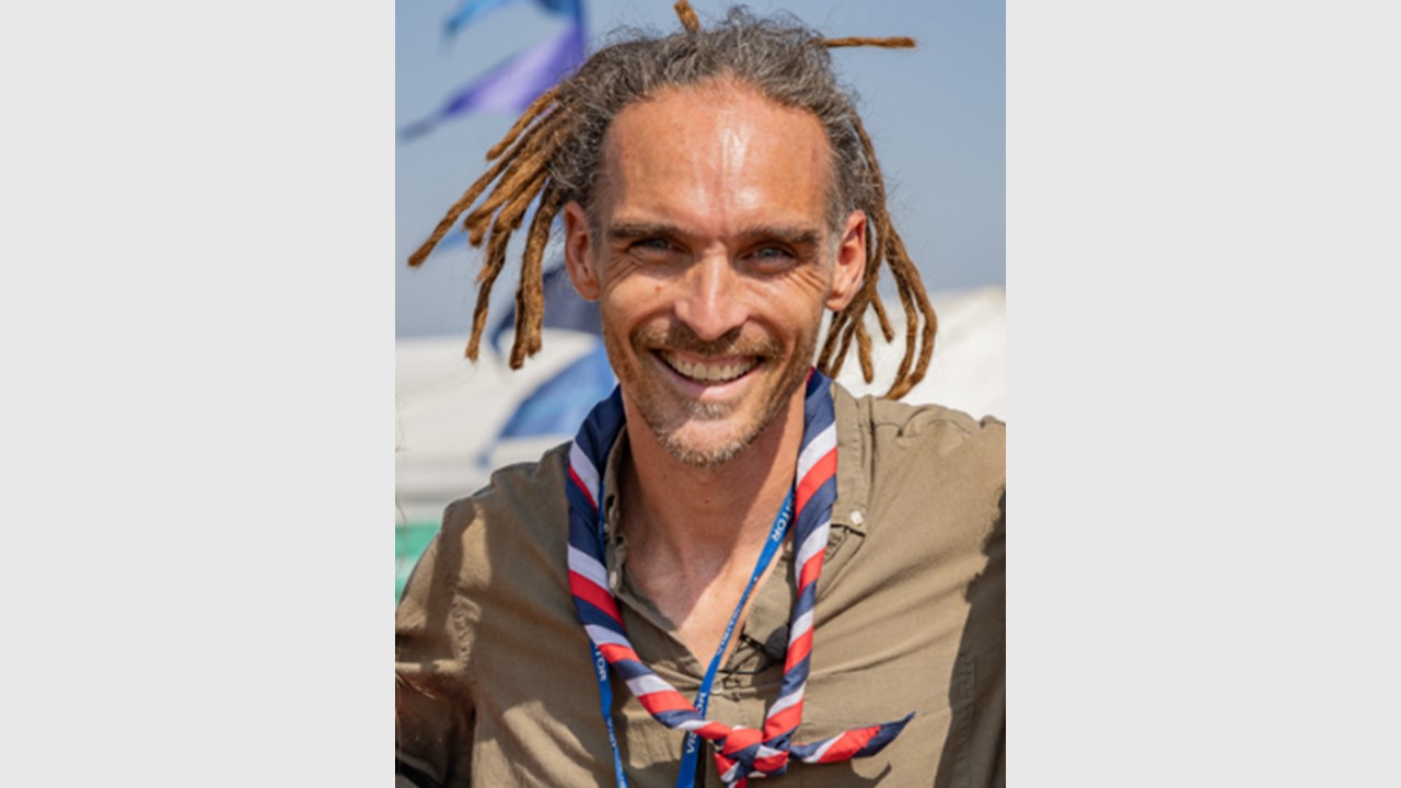 Man with dreadlocks and a Scouts necker