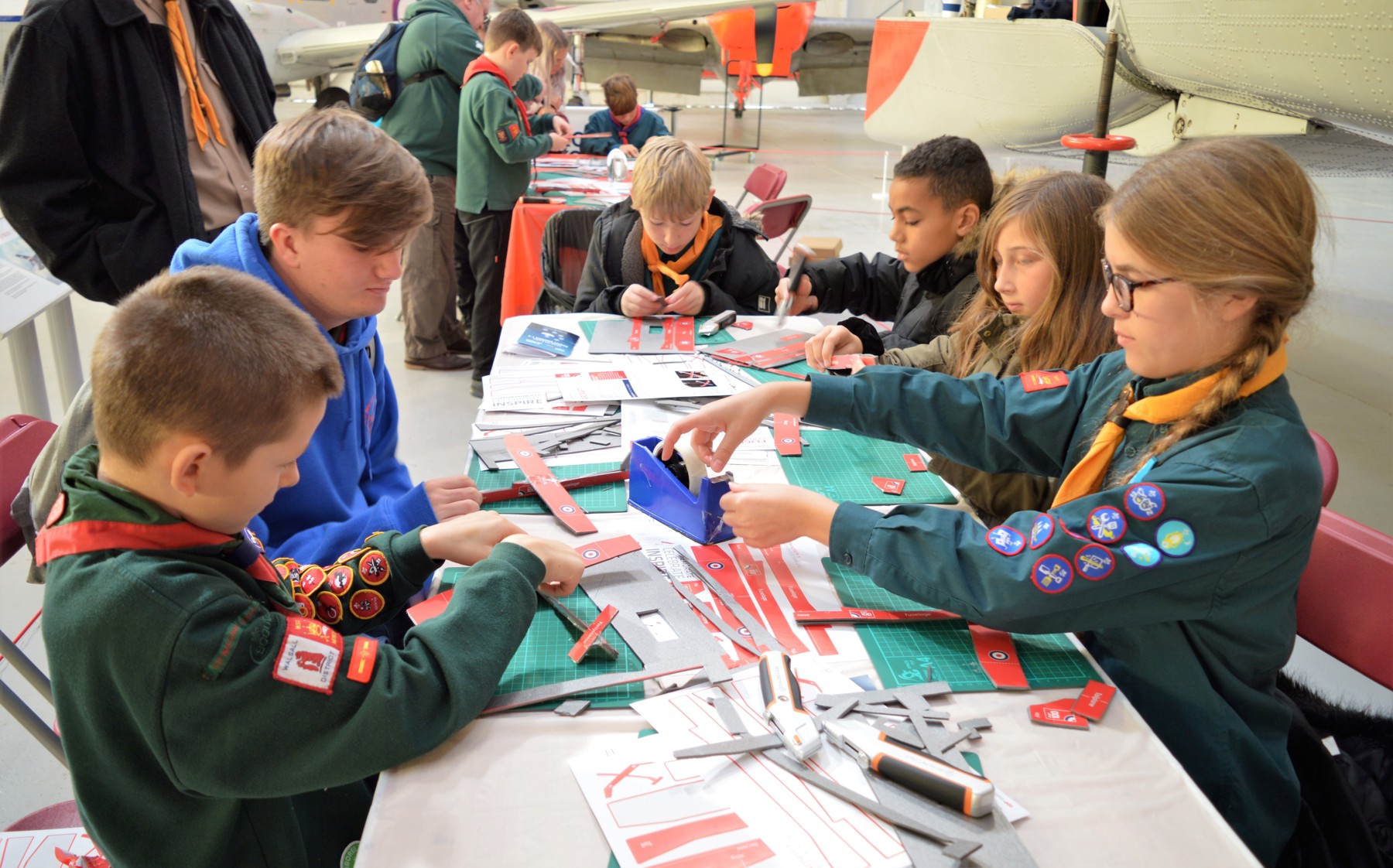 A group of Scouts sitting around a table doing an RAF activity.