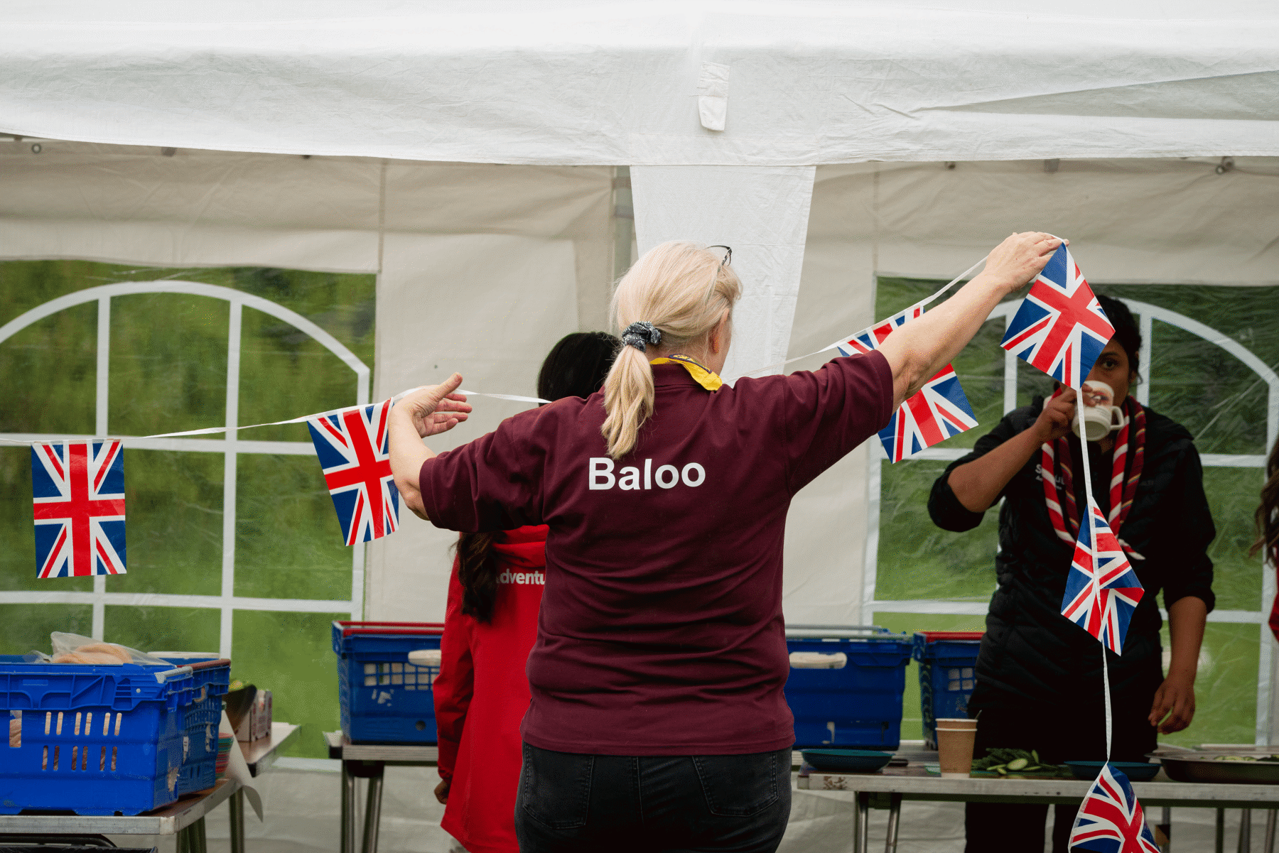 A volunteer putting up bunting at a local event