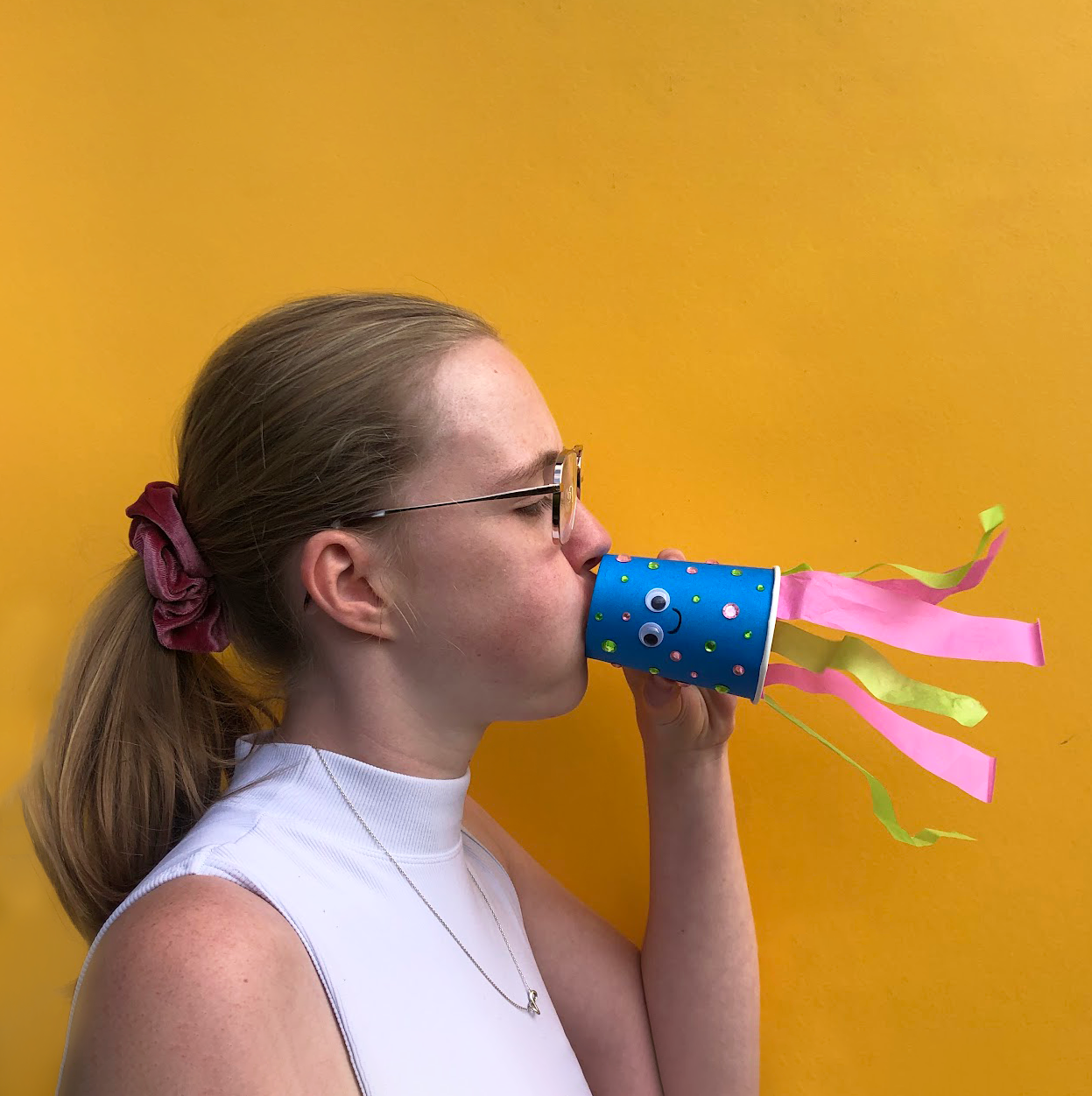 Somone breathing into a paper cup that has tissue paper on the other end to make it float.