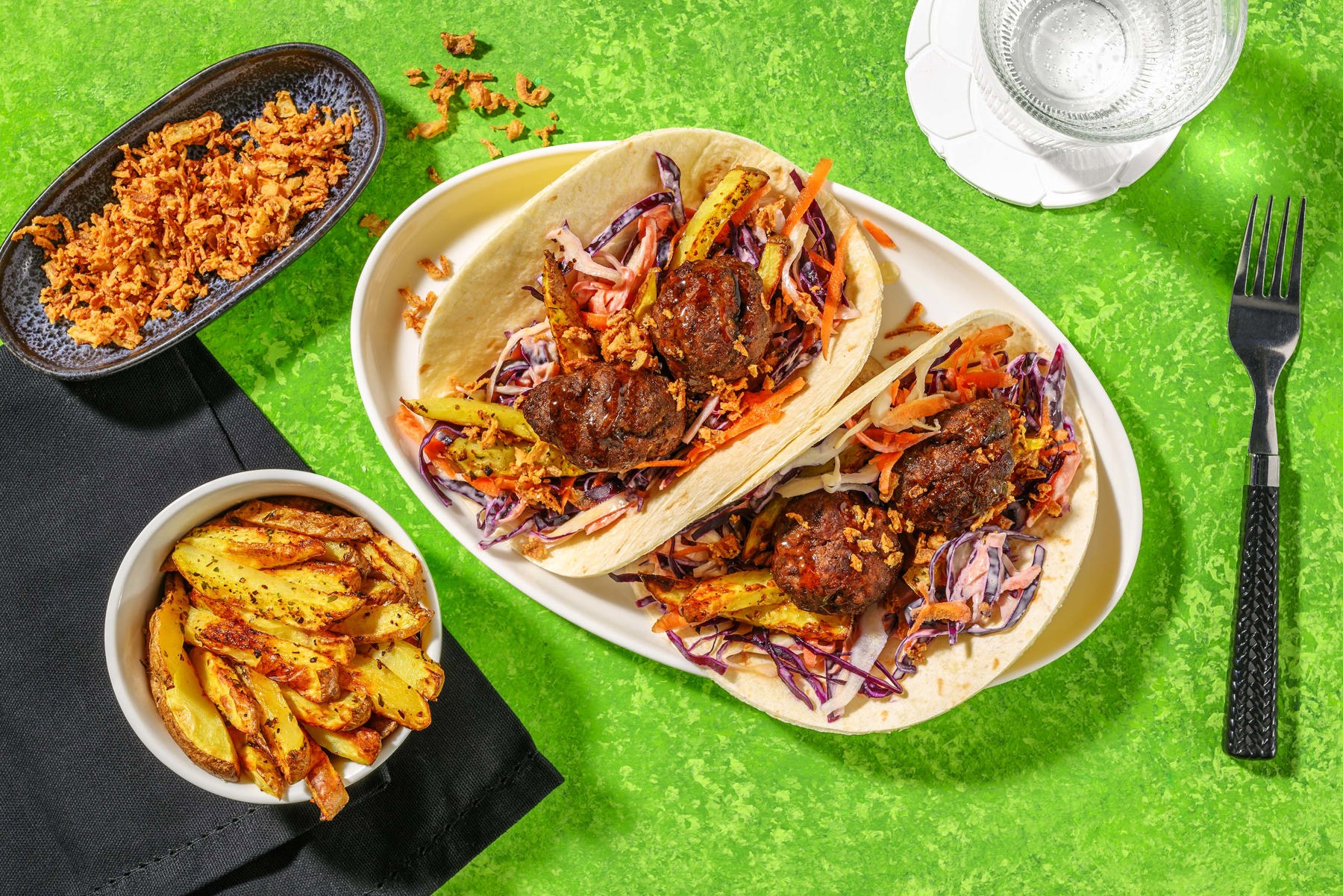 Plate of beef tacos, with a bowl of chips and coleslaw.
