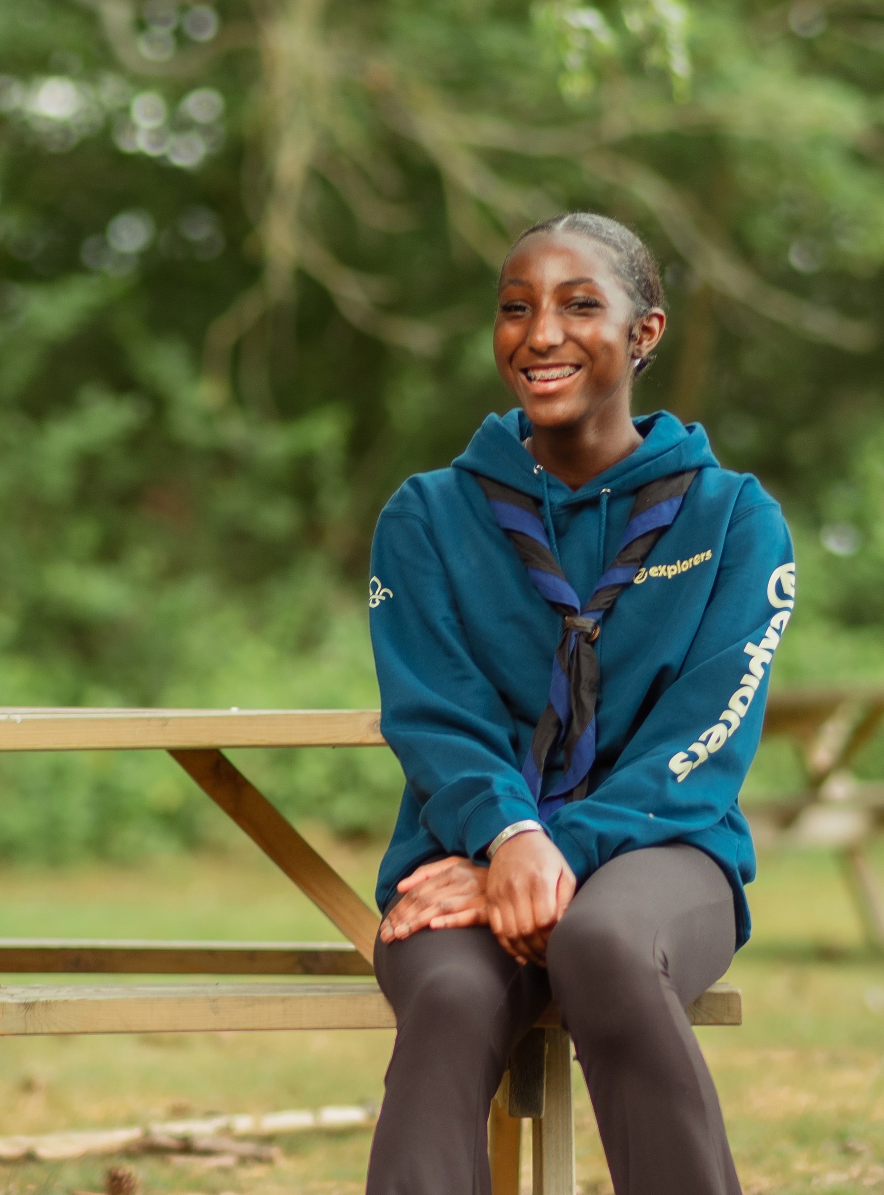 Elie, wearing an Explorers hoodie and necker, smiles at the camera.