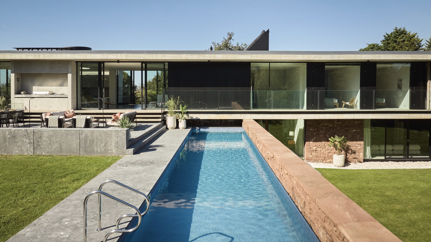 A modern two storey house with swimming pool in the foreground.