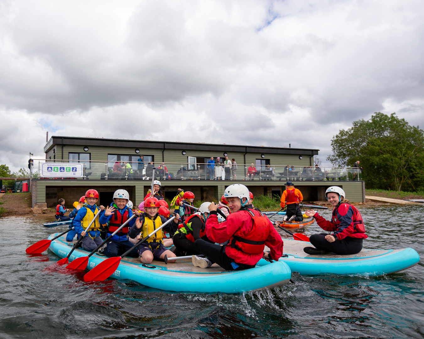 A group of young people pose for a picture while taking part in a water activity.