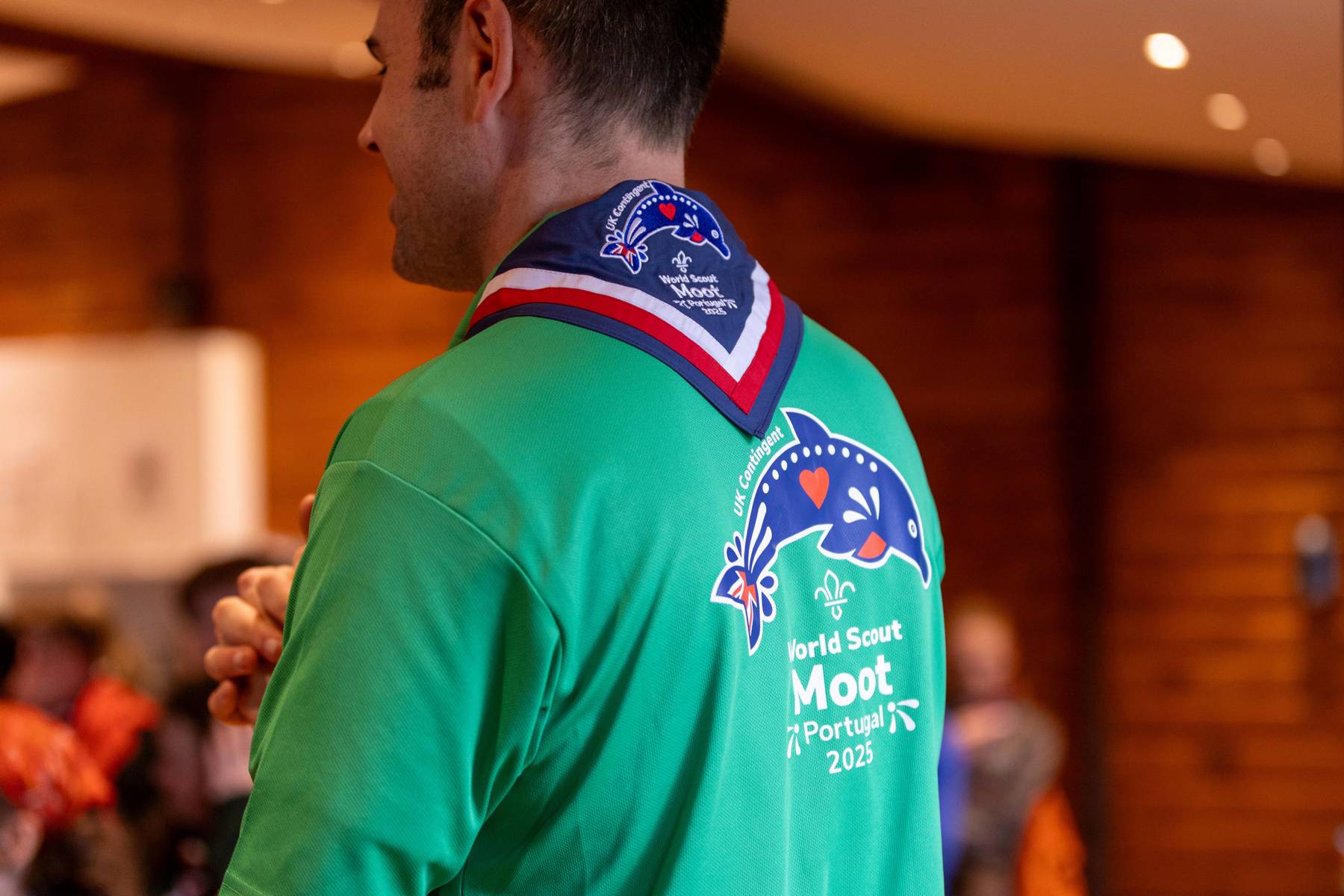 UK Contingent volunteer in a green t-shirt and necker