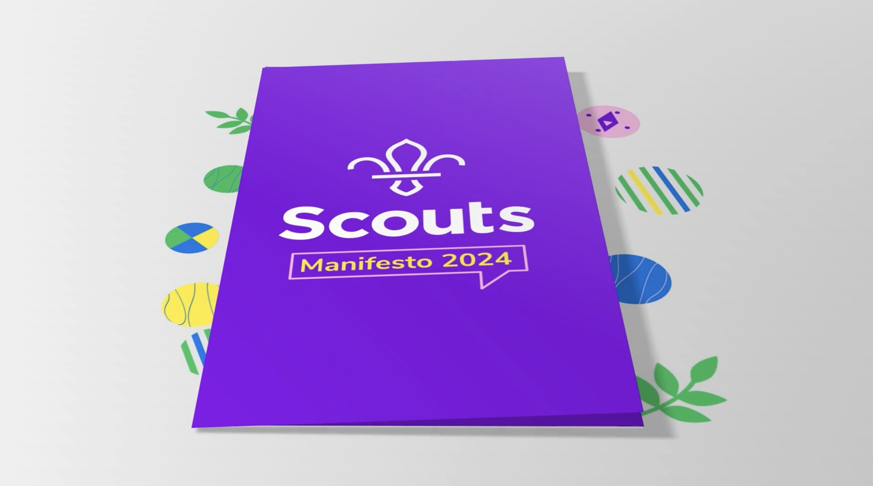 The photo shows a purple digital scrapbook with a white fleur-de-lis and the text 'Scouts' underneath. Below that it says 'Manifesto 2024'. Either side of the scrapbook are graphic pattern icons including leaves and circles.