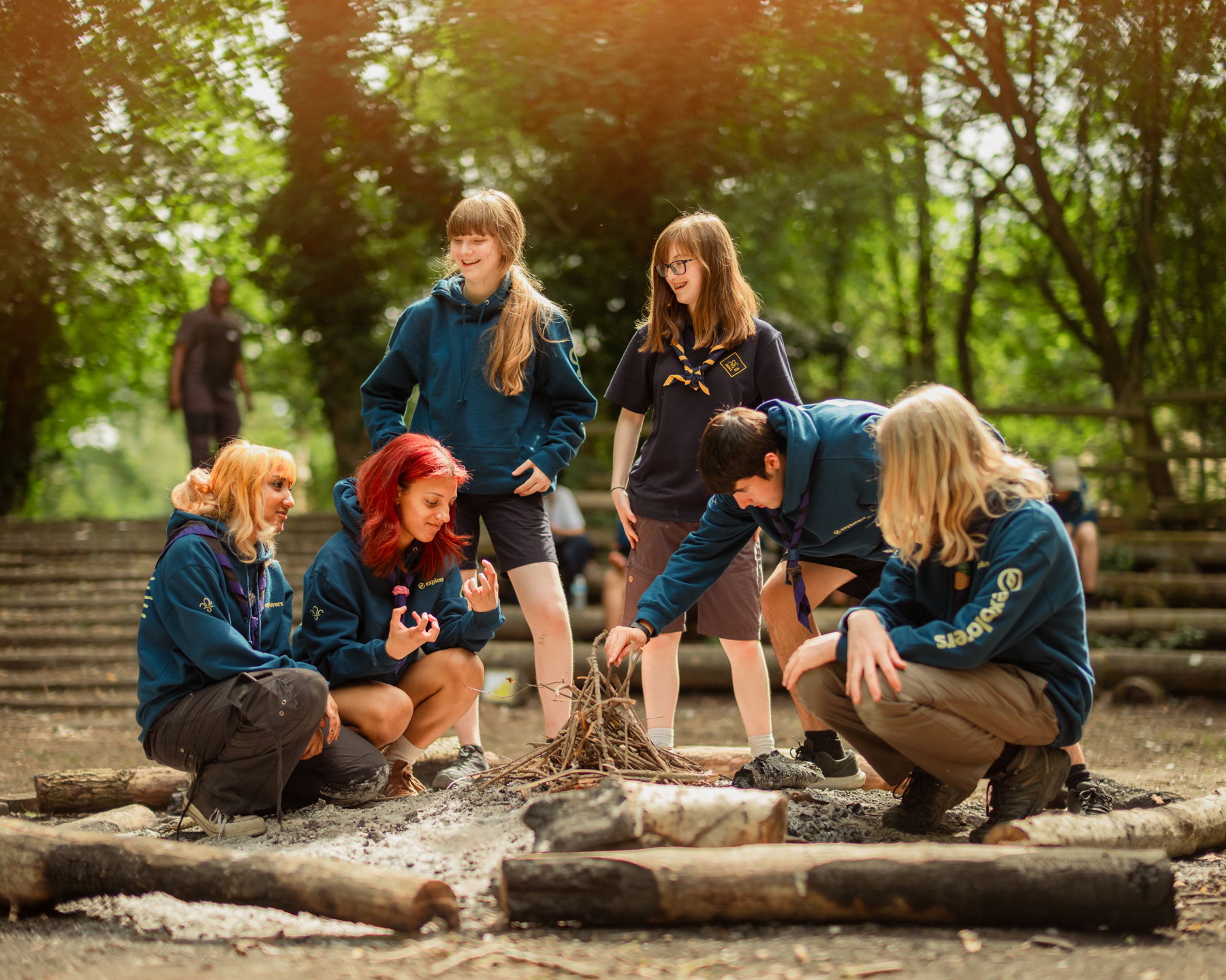 A group of Explorers build a campfire.