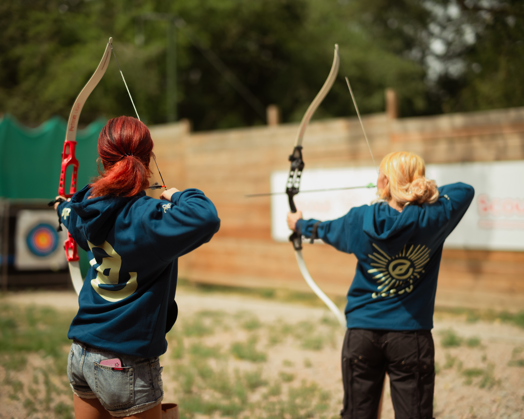 Two Explorers with their backs to the camera take part in an archery activity