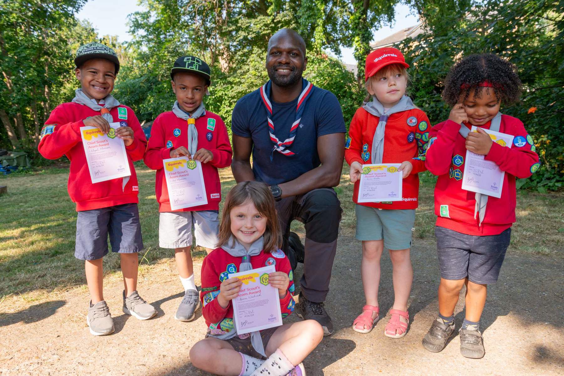 Image shows Chief Scout Dwayne Fields smiling with a group of Squirrels in uniform