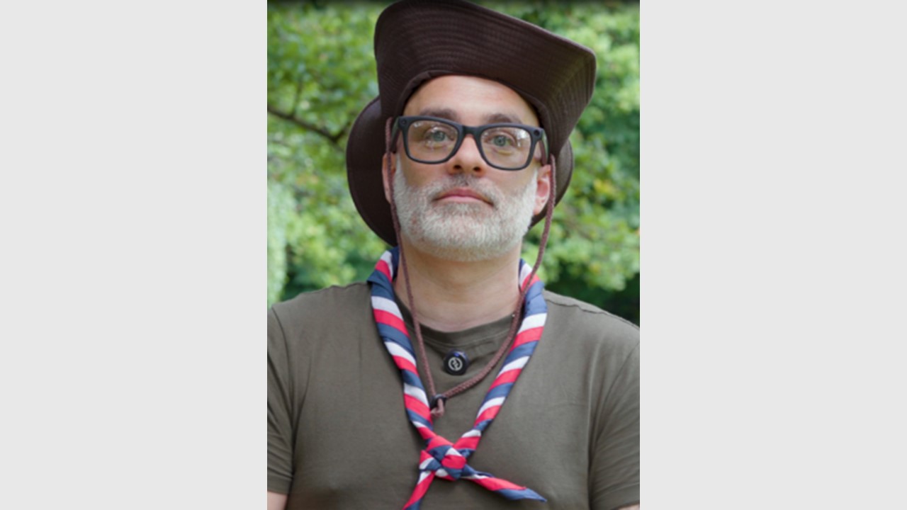 Man with white beard, glasses and black hat