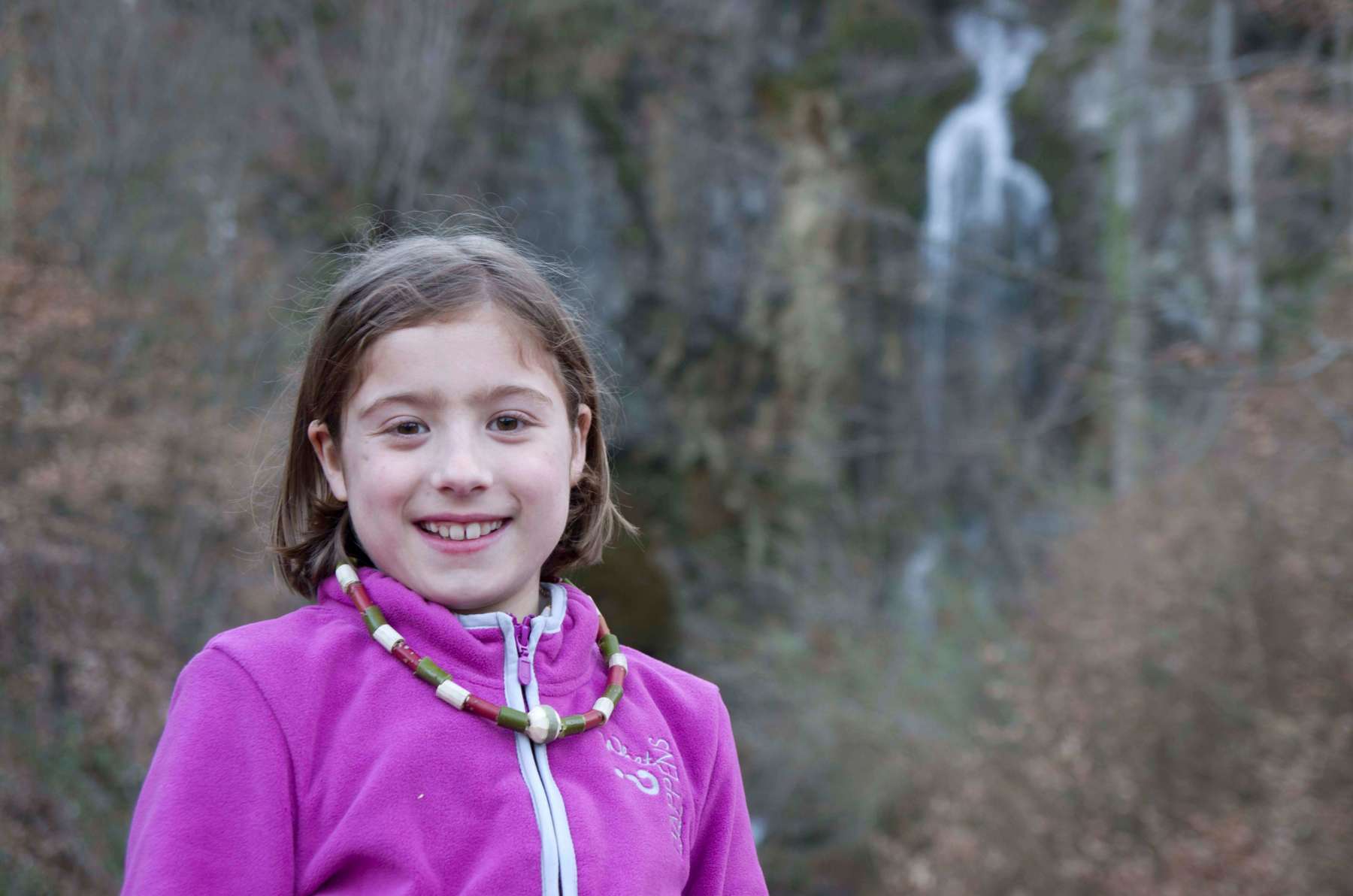 Girl in a woodland wearing the finished necklace.