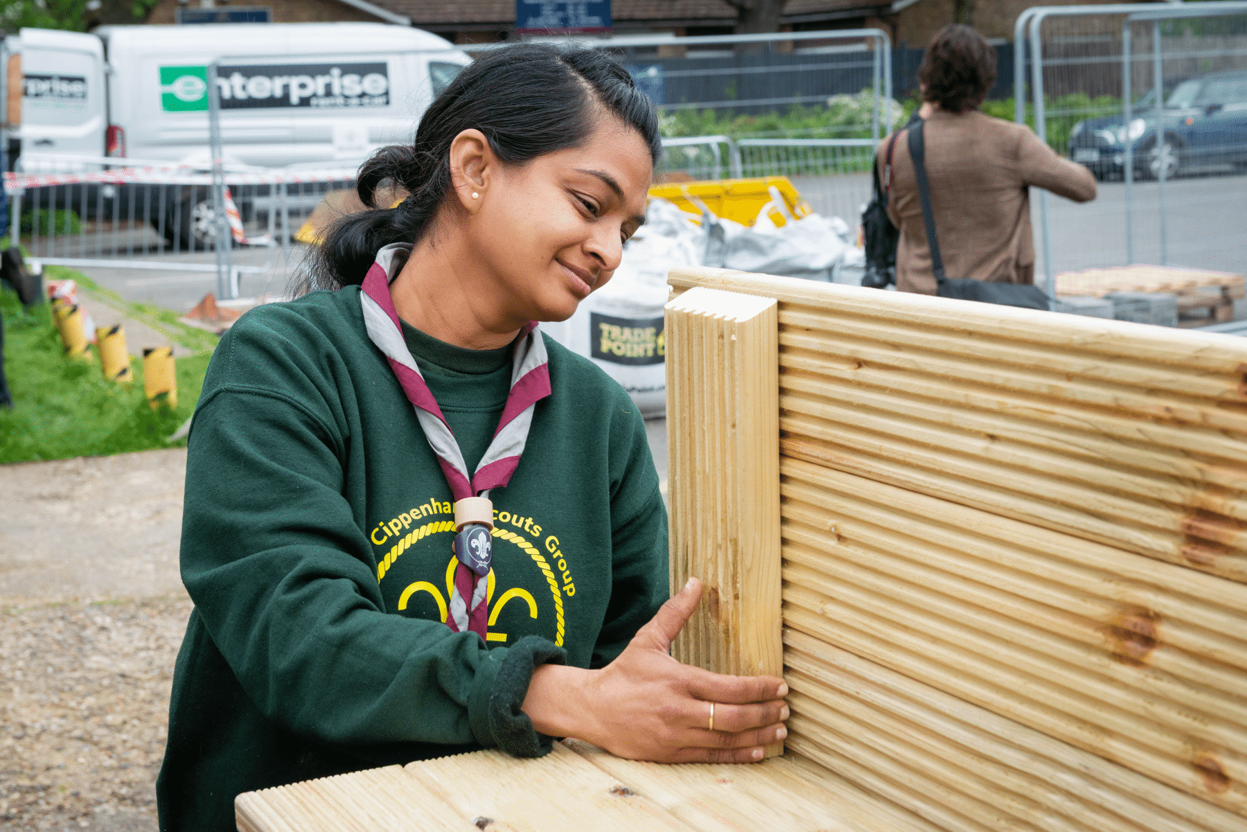 A girl wearing a necker and putting a planter together