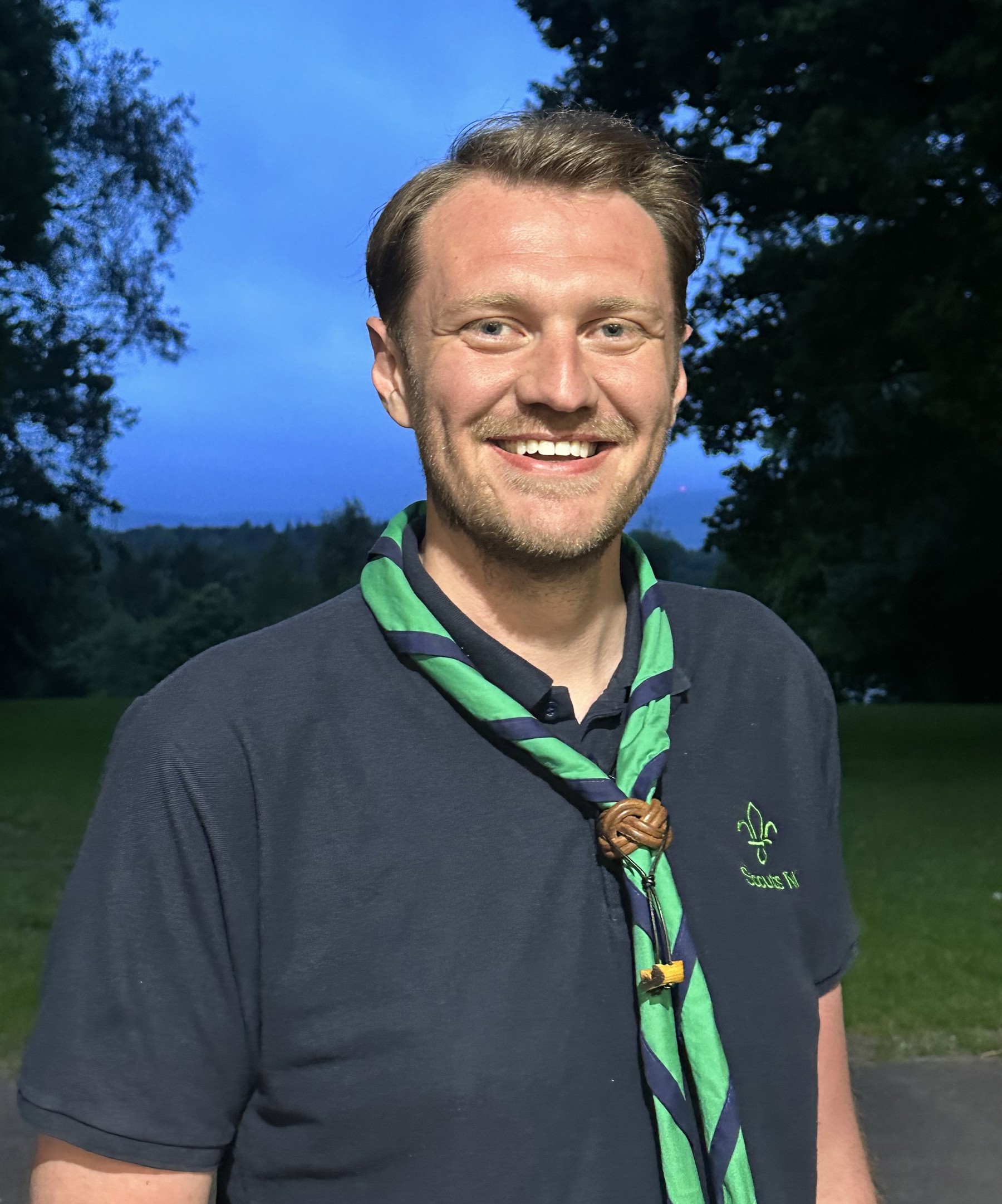 Stephen Bell stood outside with a green scout scarf around his neck